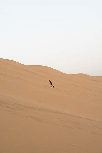 nature man climbing sand dunes outdoors