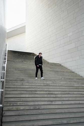 handrail man walking near stairway during daytime banister
