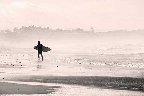 beach silhouette person walking on sandbank while holding surfboard sports