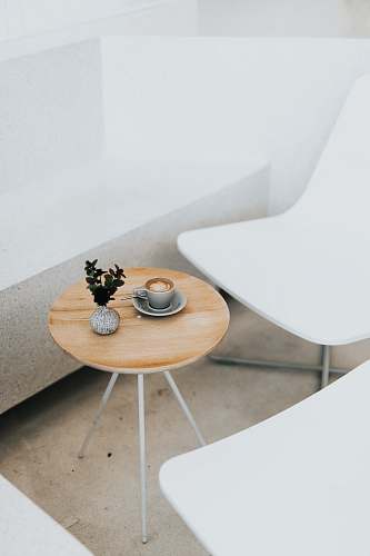 furniture round brown table beside two white chairs coffee table