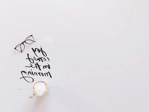 handwriting brown eyeglasses and latte on top of joy comes in the morning note white