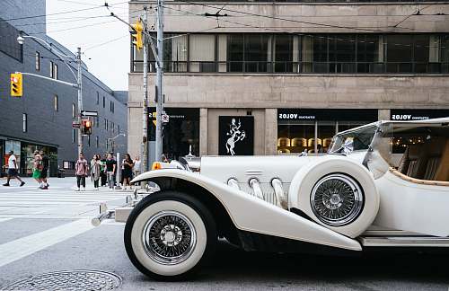 car photo of classic white vehicle near pedestrian lane automobile