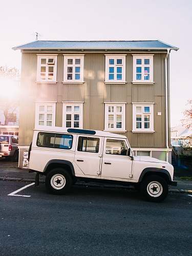 windows white vehicle near beige house jeep