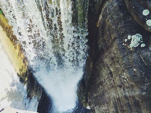 waterfall aerial photography of waterfalls surrounded by rock walls rocks