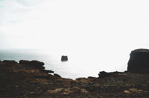 ocean black boat surrounded by water shoreline