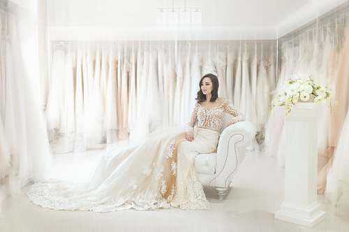 lace woman sitting on white leather armchair inside house dress