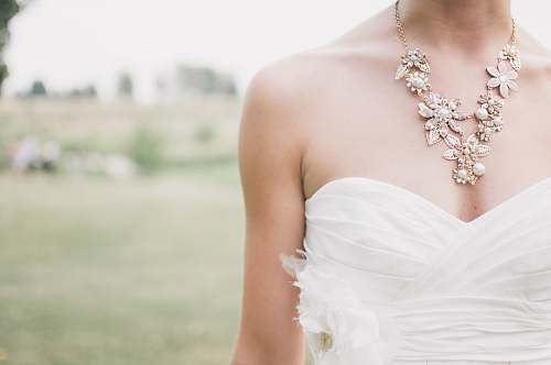 gown woman standing in grass field jewelry