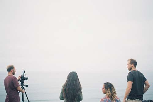 person man facing black DSLR camera with tripod human