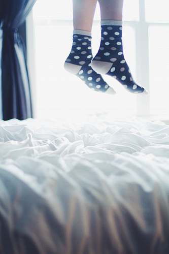 feet pair of white-and-black polka-dot socks legs