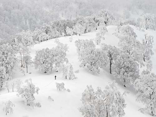 black-and-white person walking on glacier mountain snow