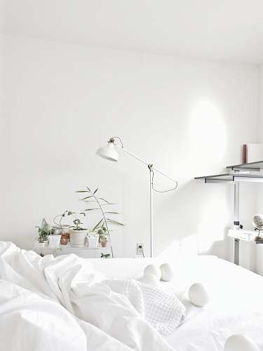 grey powered-off floor lamp beside comforter interior