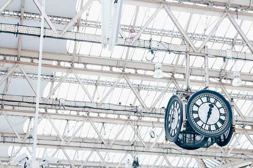 scaffolding round white and blue analog hanging clock under white trusses construction