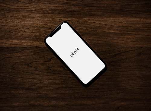 phone turned on iPhone on top of brown wooden surface iphone