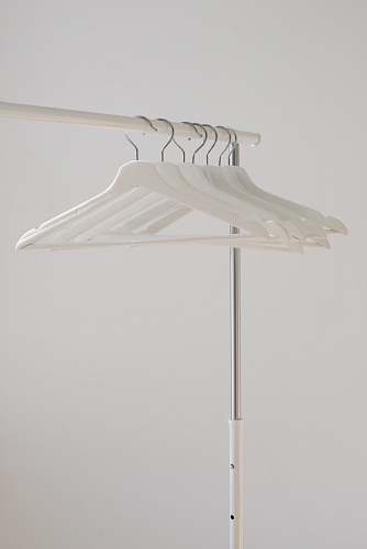 grey white clothes hangers hanging on rack home