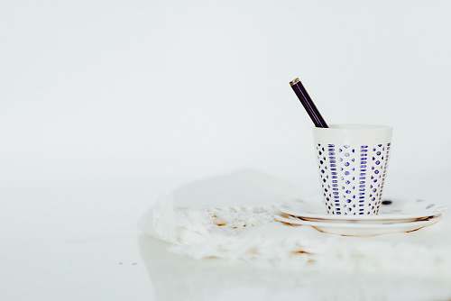 minimal white cup with pen on white panel coffee