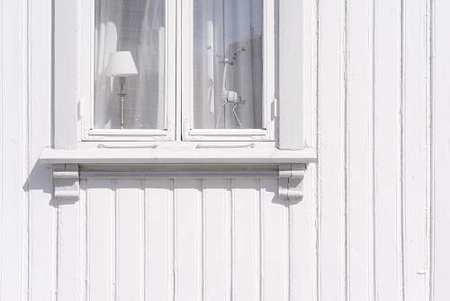 norway white wooden wall cabinet with figurine and table lamp inside light