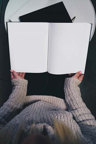 book woman wearing sweater opening blank book grey