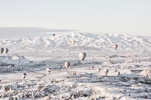 grey assorted-color air balloons below snowland at daytime hot air balloon