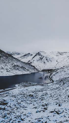 snow body of water between mountain grey