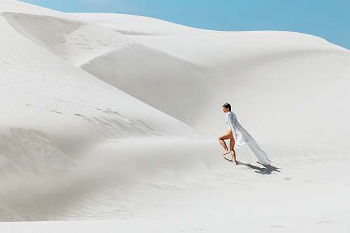 dune woman walking on white sand dunes sand