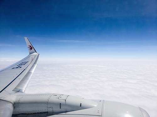 airplane aerial photo of plane flying above clouds under clear blue sky transportation