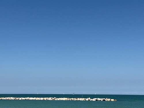 building landscape photo of the ocean with stone dock tower