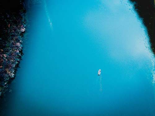 water aerial photo of boat sailing on sea sea life