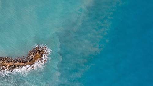 sea aerial photography of islet during daytime water