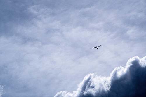sky bird flying through white clouds airplane