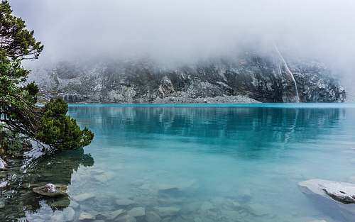 glacier blue body of water surrounded by trees mountain