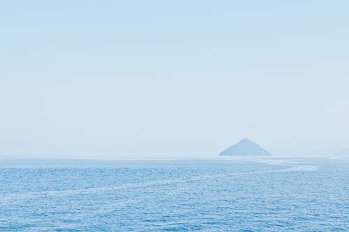 water body of water overlooking island at daytime outdoors