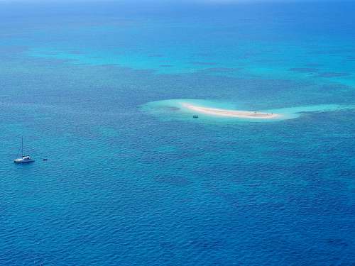 sea high-angle photography of boat near island water
