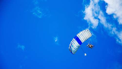 parachute low-angle photography of person riding fan-powered chair with parachute up in sky sky