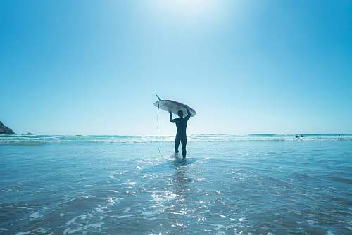 ocean man holds surfboard on water sea
