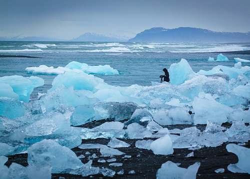 glacier man standing in middle of ice burg ice