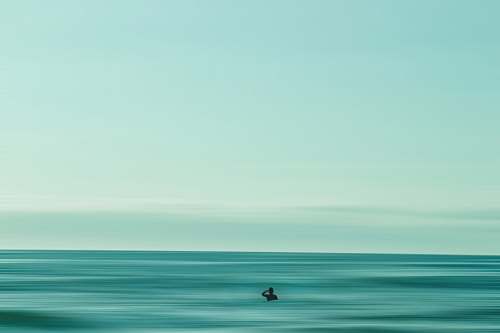 water person in middle of ocean during daytime horizon