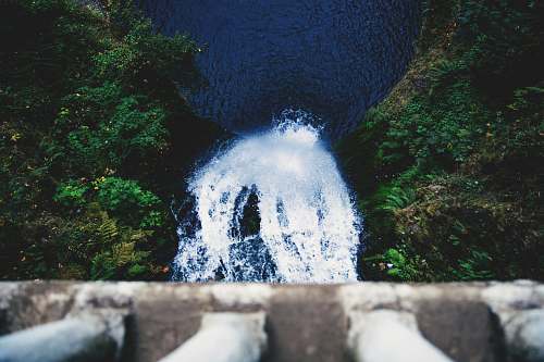 green person looking down on waterfalls tree