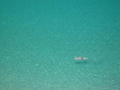teal person swimming on body of water ocean