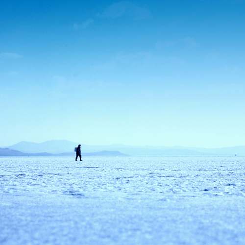 nature person walking on ice field photo sky