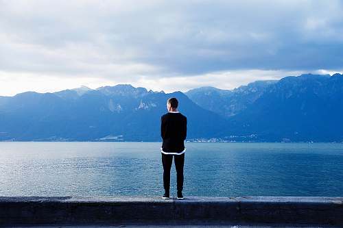 lake person wearing black pants and top standing on wall clouds