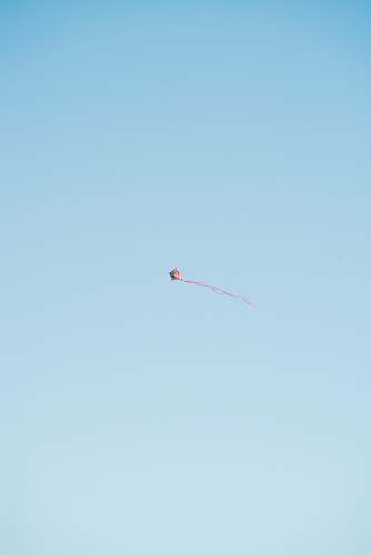 adventure red and white kite flying in the sky gliding