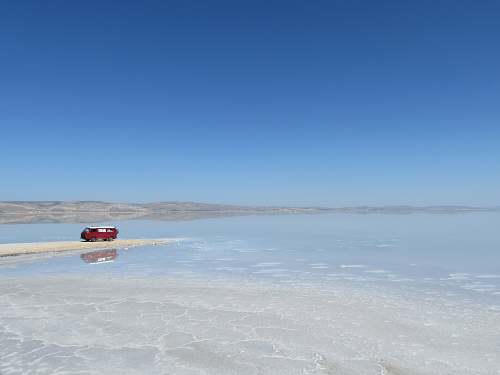 turkey red and white van near sea under blue sky lake