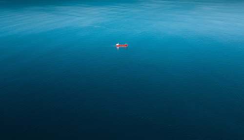 ocean red ship sailing on body of water alone sea