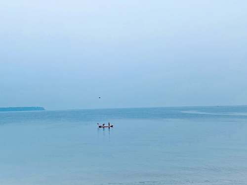 ocean silhouette of person riding boat nature