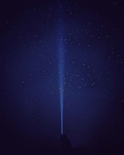 astronomy silhouette of person with flash light under starry night galaxy