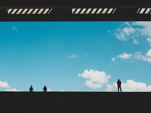 building silhouette of three person against blue sky landing page
