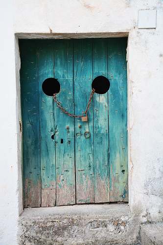 door teal wooden door with gray chain and brown padlock italy