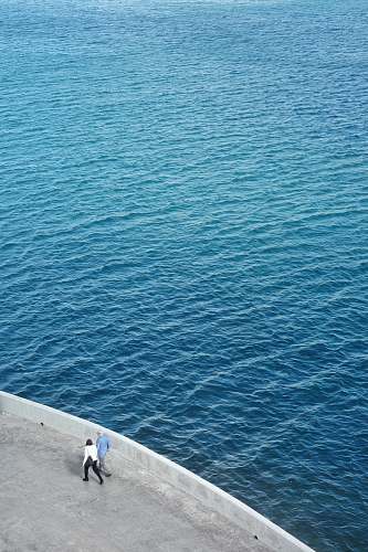 ocean two persons walking near body of water malta
