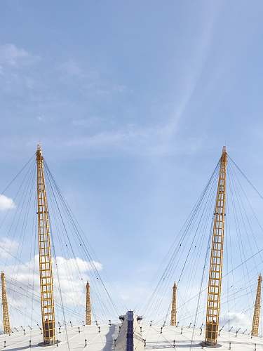 london two yellow cable towers under blue sky the o2 arena