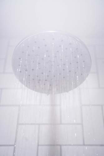 room water from round gray stainless steel shower head indoors